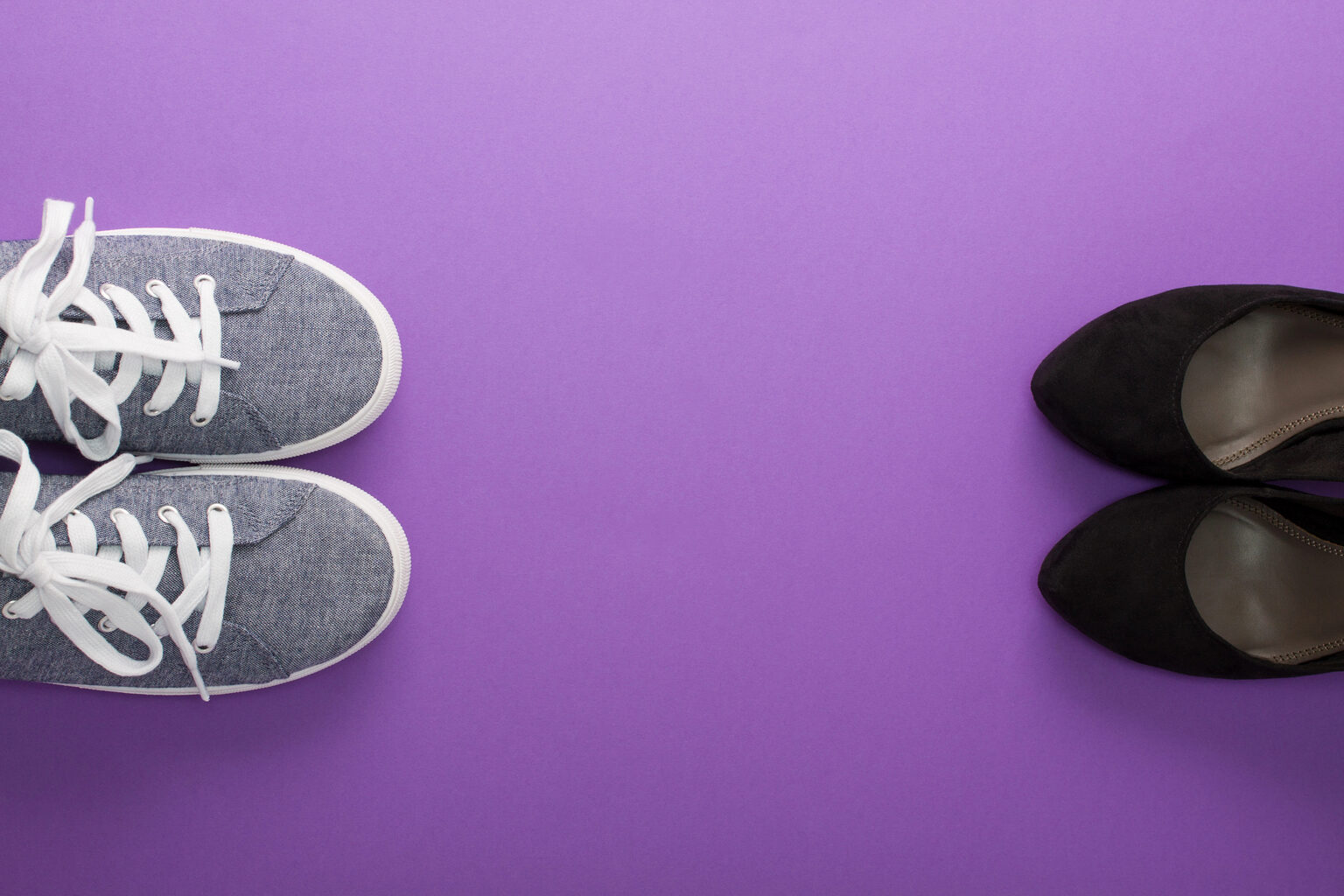 A pair of sneakers facing a pair of dress shoes